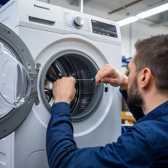 Technician working on the drum of a front-loading washing machine